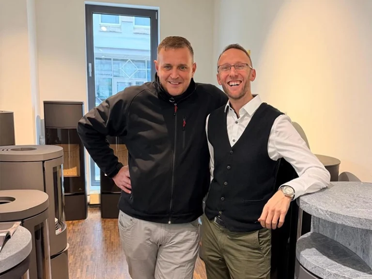 Teamfoto im Ofenstudio zwischen Kaminöfen und Feuerstellen